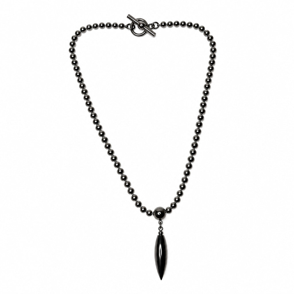 A dark metallic beaded necklace with a toggle clasp and a teardrop-shaped pendant, shown on a plain white background.