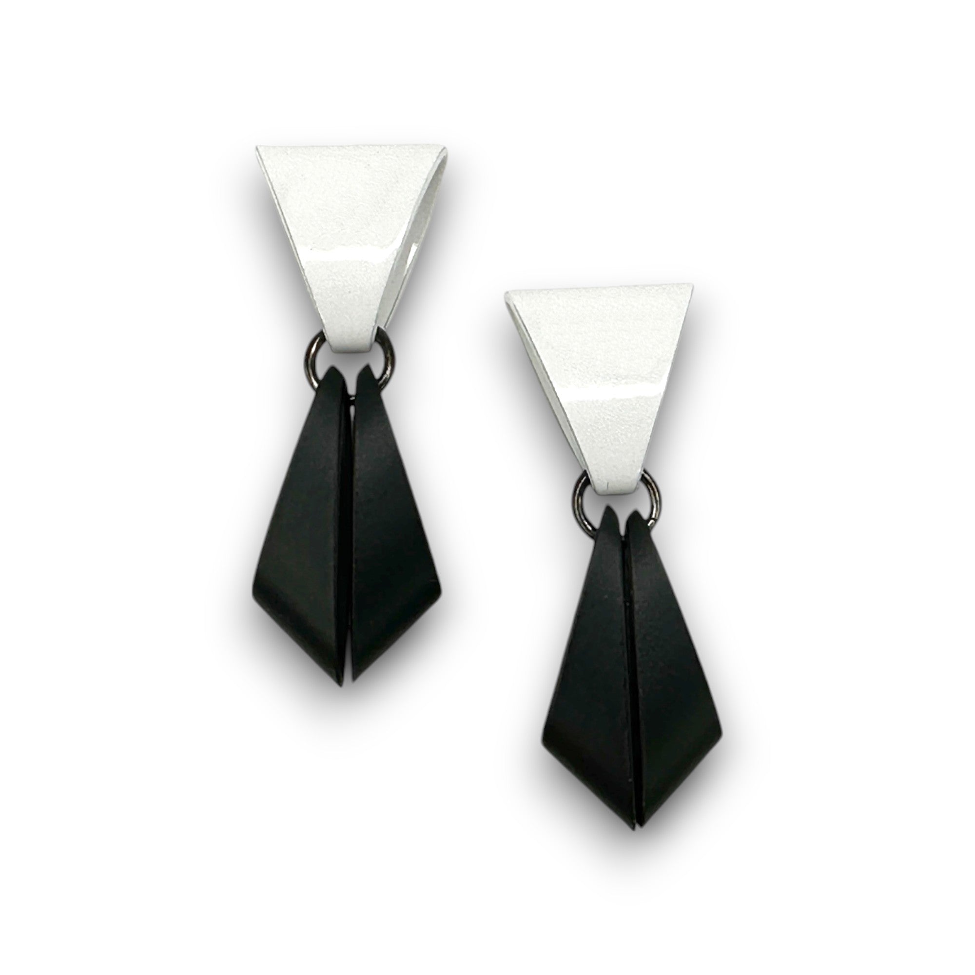 Pair of earrings with white and black geometric design on a white background