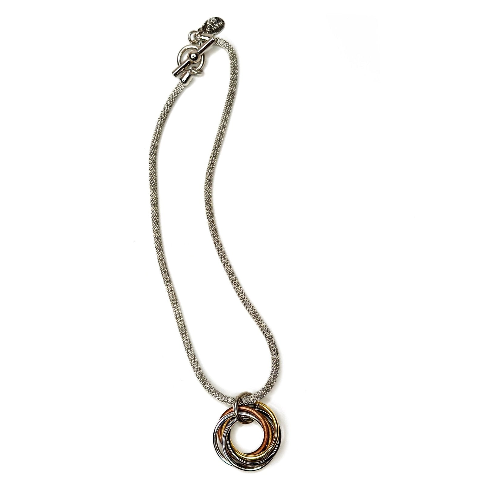 Erica Zap Designs mixed metal knot pendant necklace with silver mesh chain and toggle clasp. Features interlocking rings in gold, silver, copper, and black.